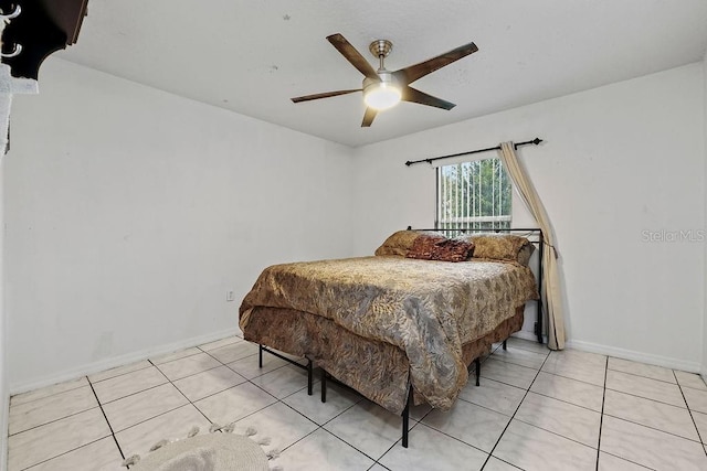 bedroom featuring ceiling fan, baseboards, and light tile patterned flooring