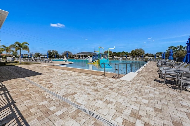 community pool with a patio area and a water play area