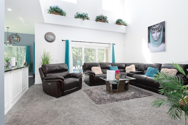 carpeted living room featuring an inviting chandelier