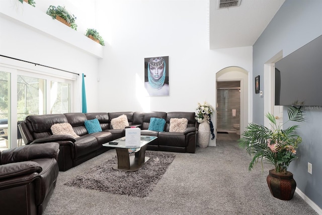 carpeted living room featuring a high ceiling