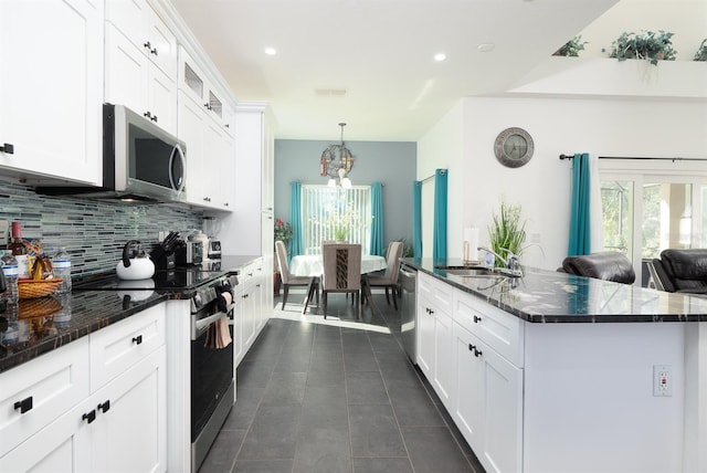 kitchen featuring a center island with sink, sink, white cabinetry, and stainless steel appliances