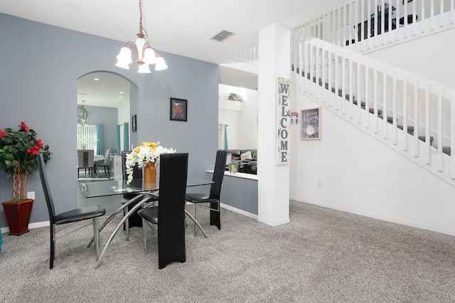 carpeted dining area featuring an inviting chandelier