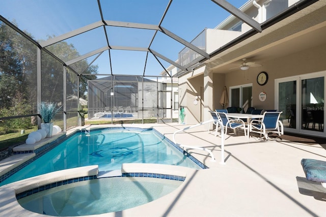 view of pool with a lanai, a patio area, ceiling fan, and an in ground hot tub