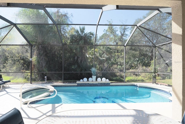 view of swimming pool featuring a lanai, a patio area, and a hot tub