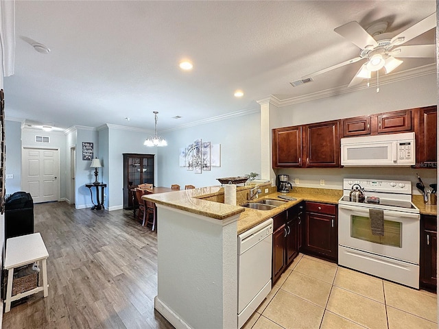 kitchen with kitchen peninsula, crown molding, sink, and white appliances