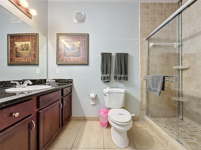 bathroom with tile patterned flooring, toilet, an enclosed shower, and vanity