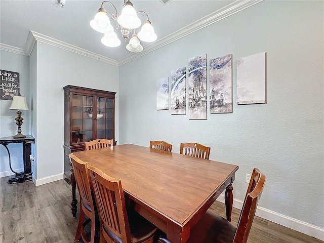 dining space featuring hardwood / wood-style floors, a notable chandelier, and crown molding