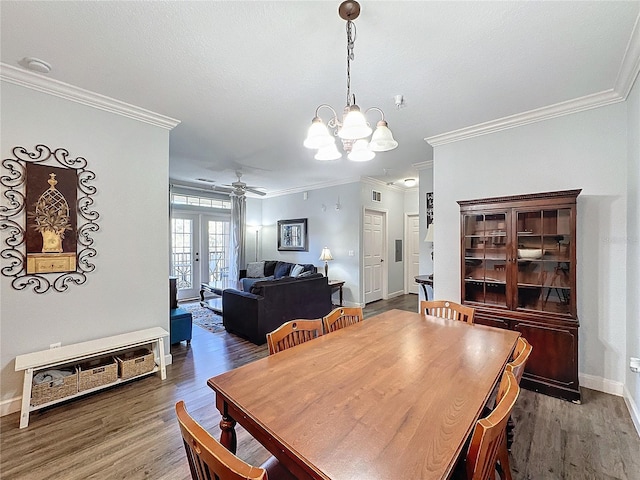 dining room featuring dark hardwood / wood-style floors, ornamental molding, ceiling fan with notable chandelier, and french doors