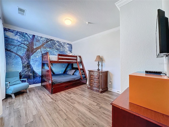 bedroom with a textured ceiling, light hardwood / wood-style flooring, and crown molding