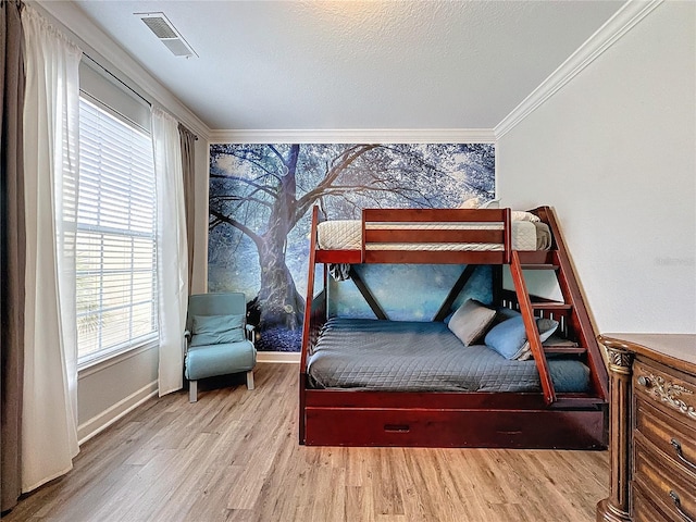 bedroom with crown molding and light hardwood / wood-style flooring