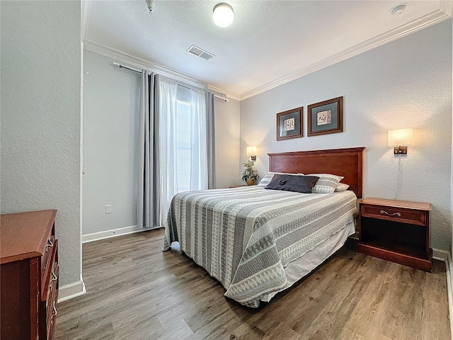 bedroom with ornamental molding and light hardwood / wood-style flooring