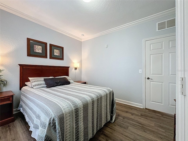 bedroom with dark hardwood / wood-style floors and ornamental molding