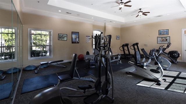 workout area featuring a tray ceiling and ceiling fan