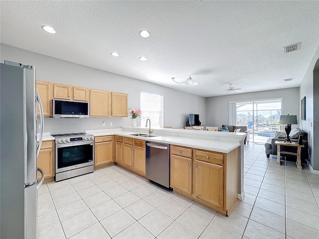 kitchen featuring kitchen peninsula, appliances with stainless steel finishes, a textured ceiling, ceiling fan, and sink