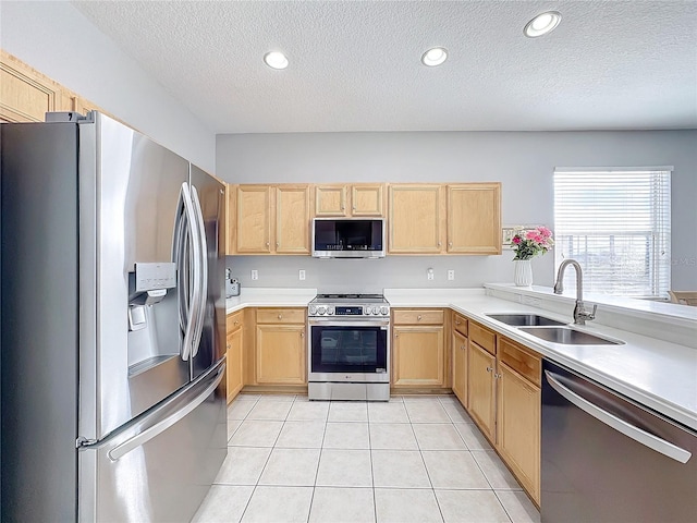 kitchen with light brown cabinets, sink, a textured ceiling, appliances with stainless steel finishes, and light tile patterned flooring