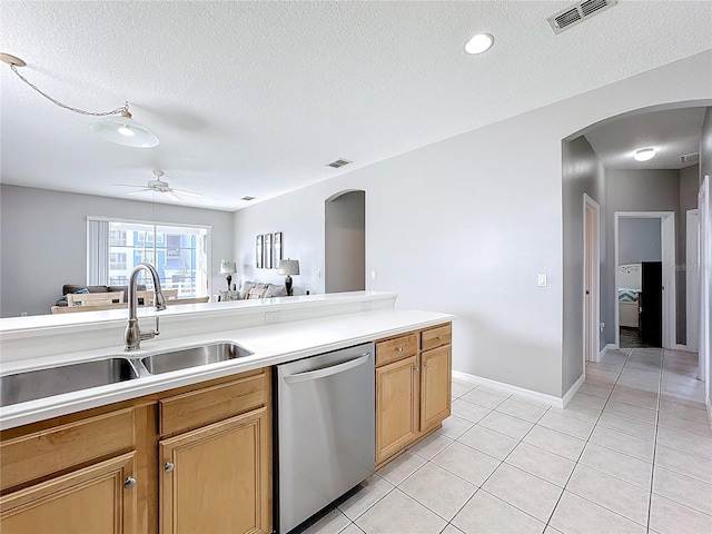 kitchen with sink, stainless steel dishwasher, ceiling fan, a textured ceiling, and light tile patterned flooring