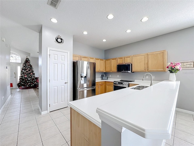 kitchen with light brown cabinets, sink, light tile patterned flooring, kitchen peninsula, and stainless steel appliances