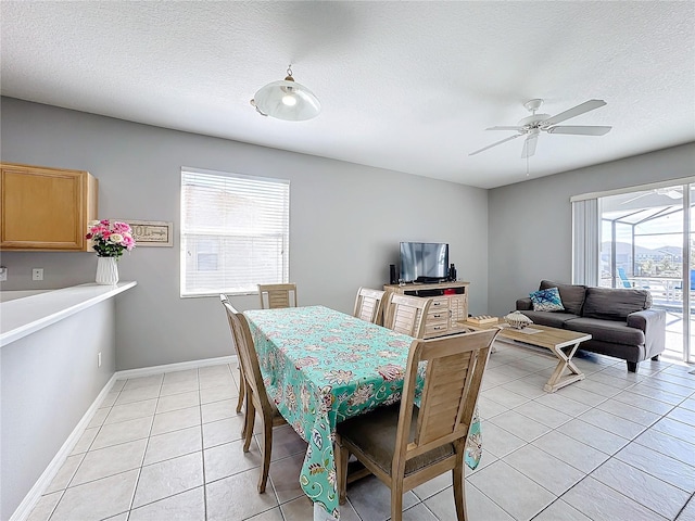 tiled dining area featuring a wealth of natural light, ceiling fan, and a textured ceiling