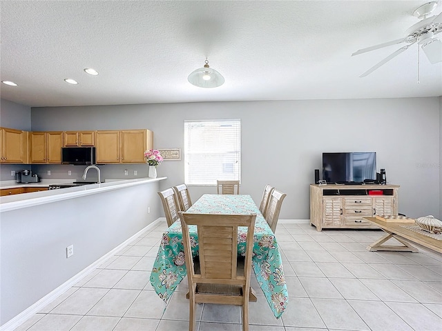 dining room featuring light tile patterned floors, a textured ceiling, and ceiling fan