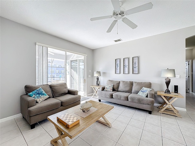 tiled living room featuring ceiling fan and a textured ceiling