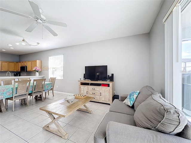 living room with ceiling fan, light tile patterned flooring, and sink