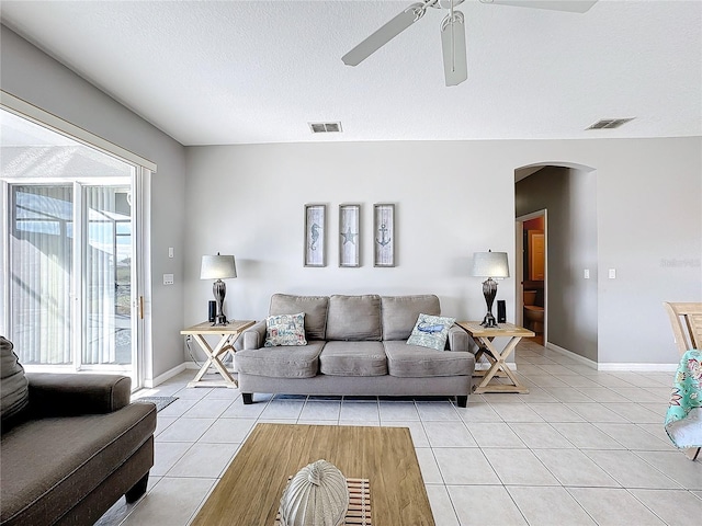 tiled living room featuring a textured ceiling and ceiling fan