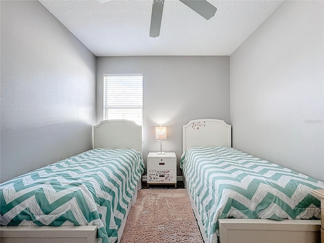 bedroom with ceiling fan and a textured ceiling