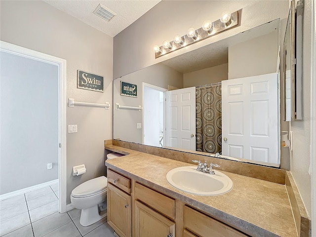 bathroom with tile patterned flooring, vanity, toilet, and a textured ceiling