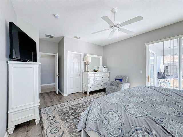 bedroom with hardwood / wood-style floors, ceiling fan, a textured ceiling, and access to outside