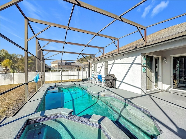 view of pool featuring glass enclosure, an in ground hot tub, and a patio