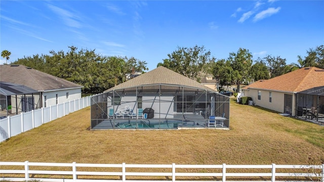 rear view of property with a patio area, a lanai, a fenced in pool, and a yard