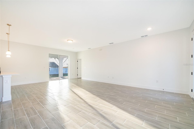 interior space featuring wood tiled floor, visible vents, baseboards, and recessed lighting