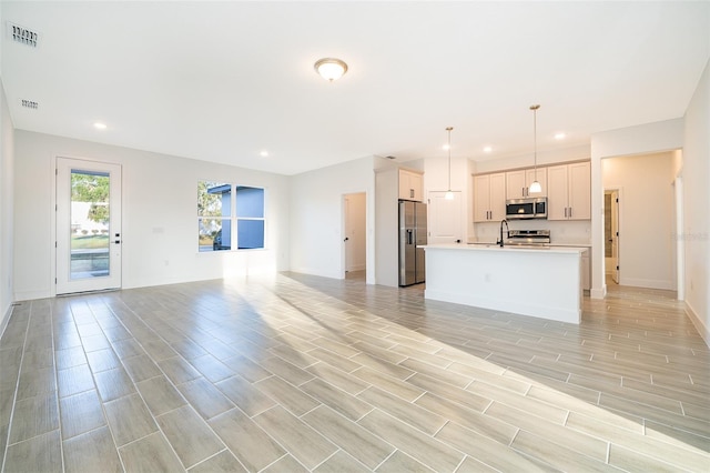 unfurnished living room with recessed lighting, visible vents, baseboards, and wood tiled floor