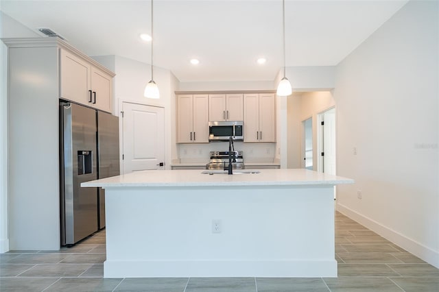 kitchen featuring an island with sink, visible vents, stainless steel appliances, and hanging light fixtures