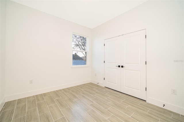 empty room featuring wood tiled floor and baseboards