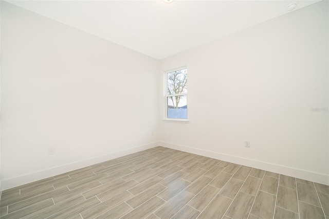 unfurnished room with wood tiled floor and baseboards