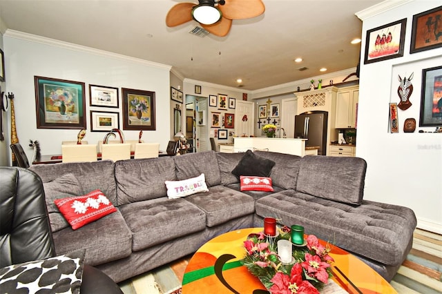 living room featuring hardwood / wood-style floors, ceiling fan, and crown molding