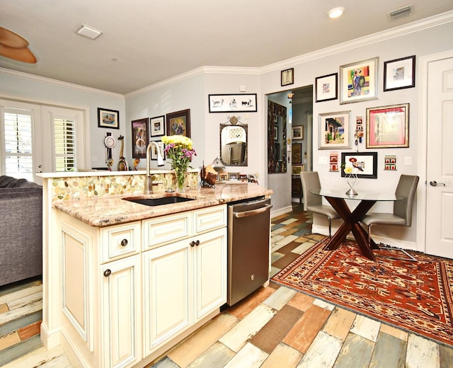 kitchen with dishwasher, cream cabinets, sink, ornamental molding, and light stone counters