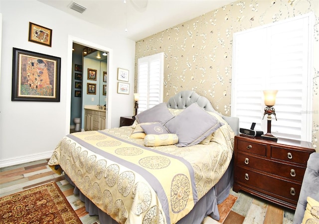 bedroom featuring light hardwood / wood-style floors and connected bathroom