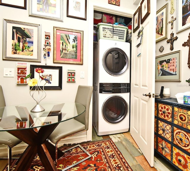 clothes washing area with stacked washer / dryer and light hardwood / wood-style flooring