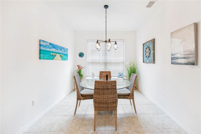 dining area with light tile patterned floors and an inviting chandelier