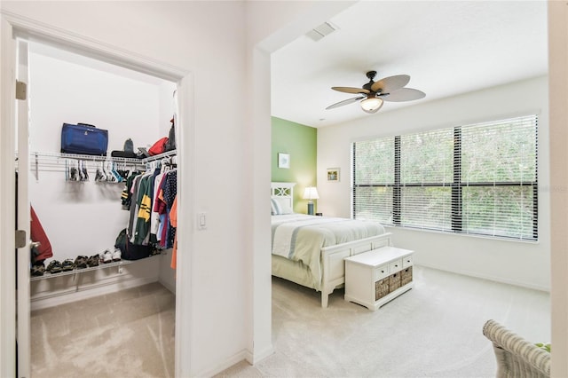 bedroom featuring multiple windows, ceiling fan, a closet, and light colored carpet