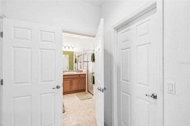 bathroom with tile patterned floors, a shower with door, and vanity