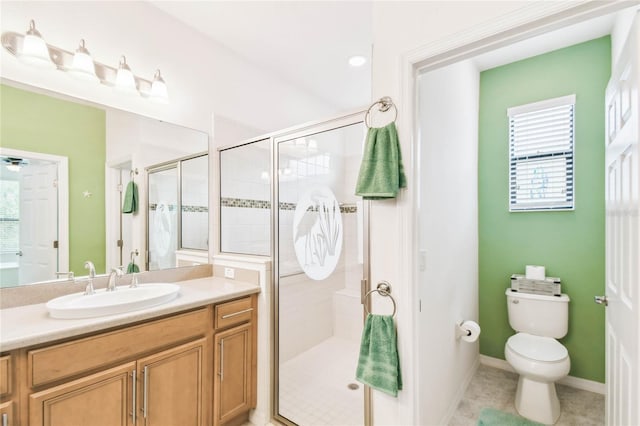 bathroom with tile patterned floors, vanity, a shower with shower door, and toilet