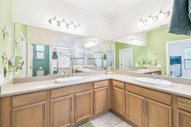 bathroom with tile patterned flooring, vanity, toilet, and a shower with shower door