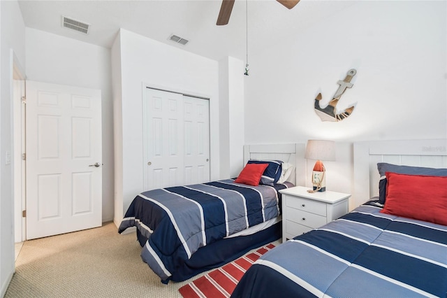 bedroom featuring ceiling fan, light colored carpet, and a closet