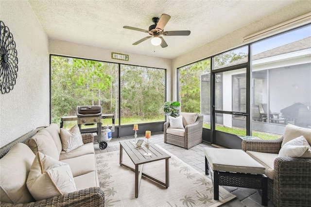 sunroom featuring ceiling fan and plenty of natural light