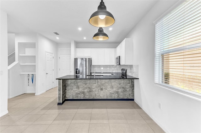 kitchen with tasteful backsplash, white cabinetry, light tile patterned floors, kitchen peninsula, and stainless steel appliances