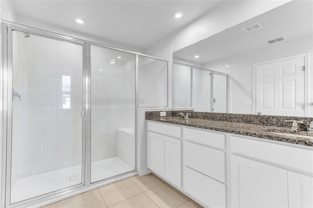 bathroom featuring tile patterned floors, an enclosed shower, and vanity