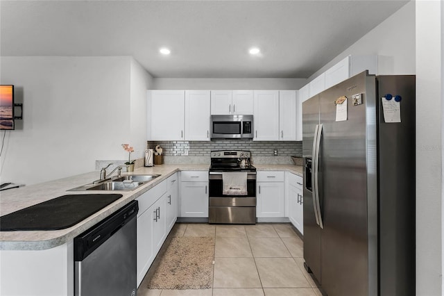 kitchen featuring white cabinets, sink, light tile patterned flooring, kitchen peninsula, and stainless steel appliances